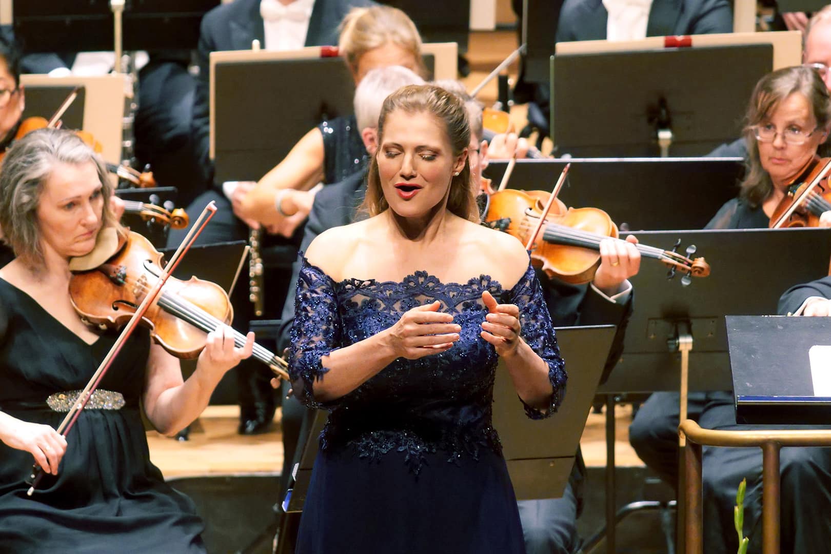 Kvinna sjunger framför orkester