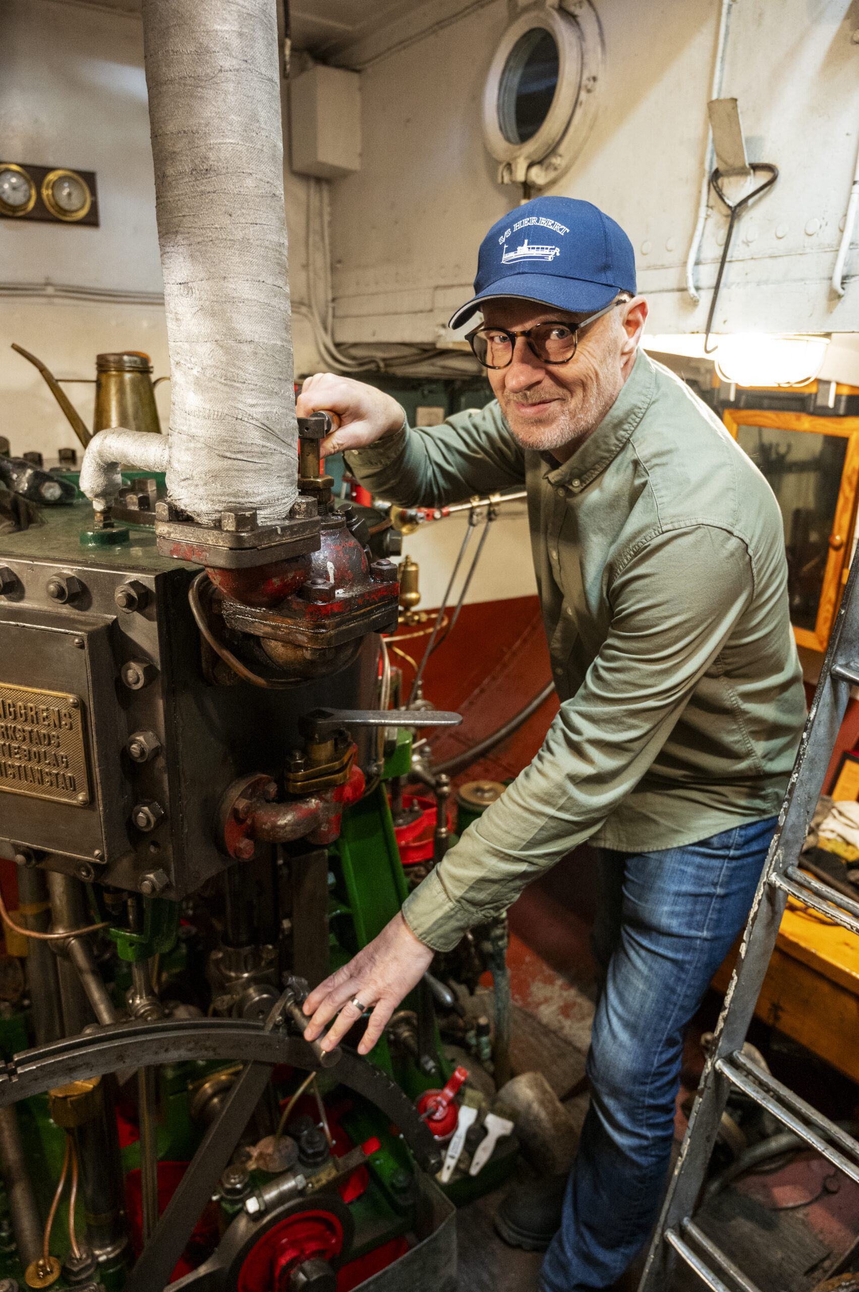 Jonas Svantesson, ordförande för Mjörns Ångbåtsförening, ombord på museiångaren S/S Herbert. Bredvid honom original-ångpannan från 1905.